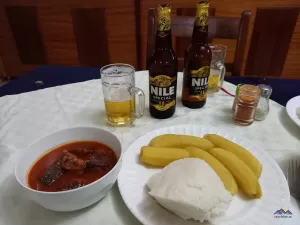 Beef Stew, Matoke (Kochbananen) und Posho (Maisbrei) und Nile Bier